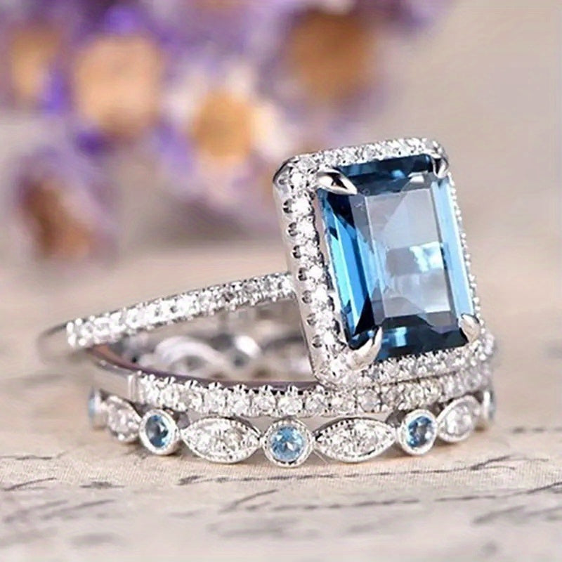 A set of three wedding rings, specially designed for brides, with a four-claw setting and square aquamarine synthetic gemstones, perfect for engagement parties and fashion jewelry.